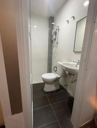 a bathroom with a toilet and a sink at Hotel O Village in Baling