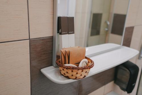 a basket sitting on a toilet in a bathroom at Hotel Sunset Beach Vama Veche in Vama Veche