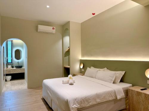 a bedroom with a bed with a teddy bear on it at Asimmy Hotel in Kampong Gurun