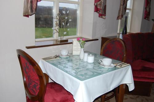 a dining room table with a white table cloth and chairs at Best Western Plus Pastures Hotel in Doncaster