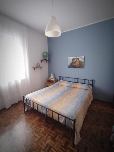 a bedroom with a large bed with a blue wall at La Ceramica in Appignano