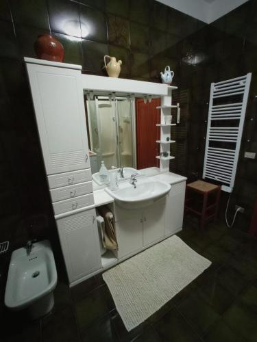 a bathroom with a sink and a mirror and a toilet at La Ceramica in Appignano
