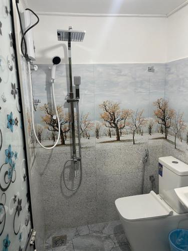 a bathroom with a shower with a toilet and trees at Ciel Grand 99 Villa in Katugastota