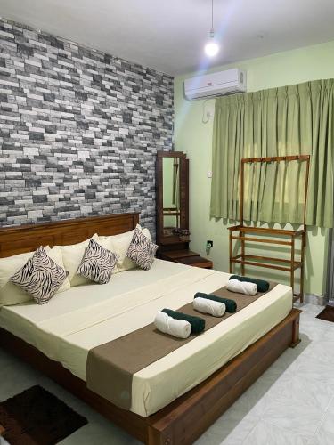 a bedroom with a large bed with pillows on it at Ciel Grand 99 Villa in Katugastota