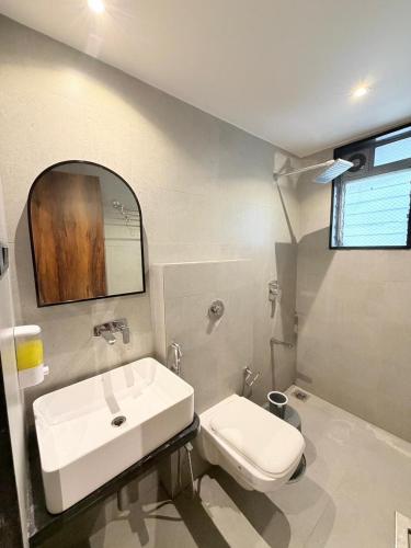 a bathroom with a sink and a toilet and a mirror at Hotel Avenue Inn in Navi Mumbai
