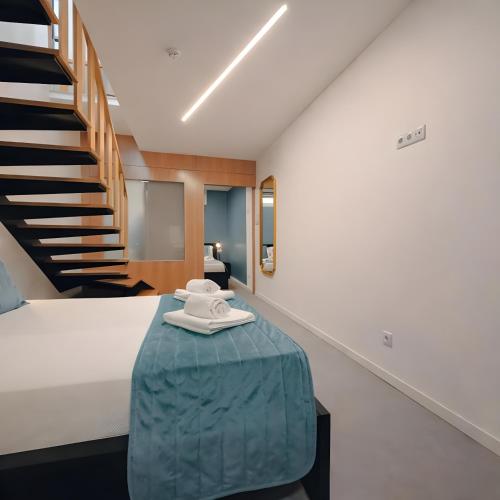 a bedroom with a bed with a blue ottoman and a staircase at SociaLodge - Piornais in Funchal