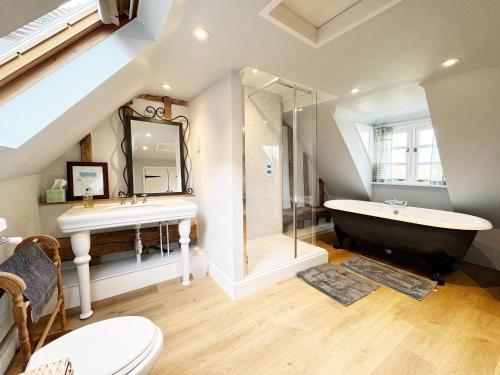 a bathroom with a sink and a tub and a toilet at Cottage Farm by The Suffolk Cottage Collection in Offton