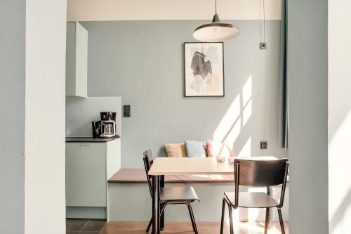 a kitchen and dining room with a table and chairs at The Nooq Malmö - Hotel & Studios in Malmö