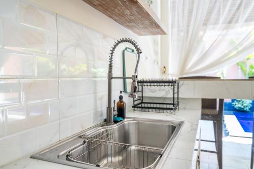 a stainless steel sink in a kitchen with a window at Villa deluna in Jimbaran