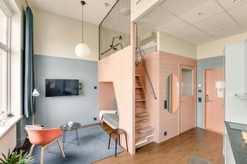 a small apartment with a staircase and a living room at The Nooq Malmö - Hotel & Studios in Malmö