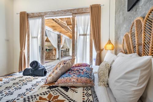 a bedroom with a bed and a large window at Villa deluna in Jimbaran