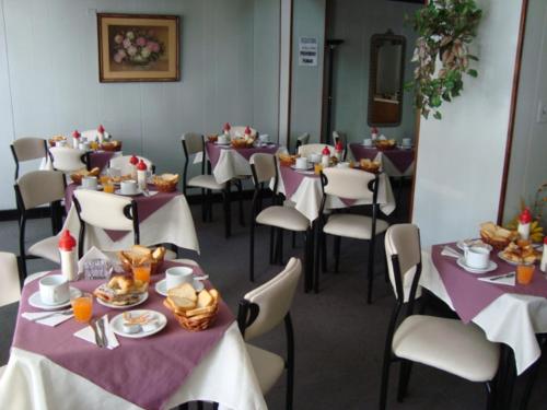 a dining room with tables and chairs with food on them at Hotel Wilton in Mar del Plata