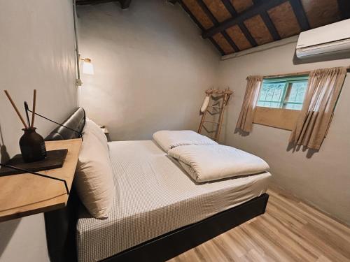 a small bedroom with a bed and a window at 楊桃墅民宿 in Chishang