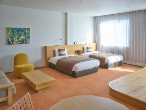 a hotel room with two beds and a table at A village in Fujikawaguchiko