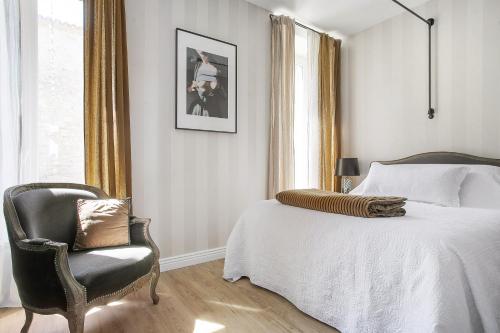 a bedroom with a bed and a chair at Alombre in Lectoure