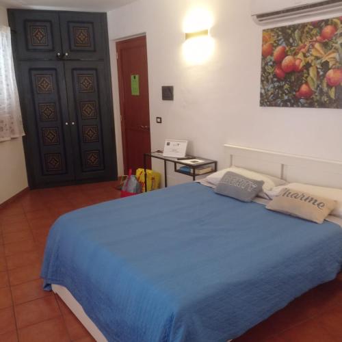 a bedroom with a bed with a blue blanket at Tok Tok Taormina in Taormina
