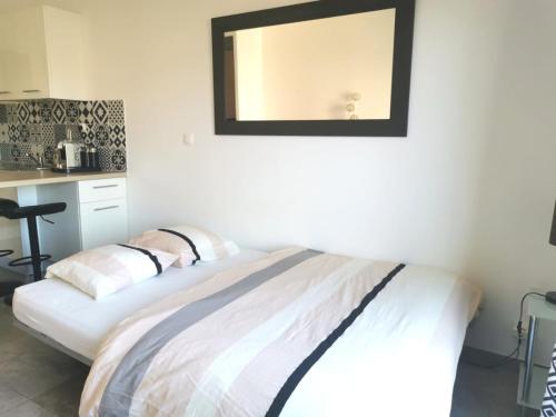 a bedroom with a bed with a mirror on the wall at Studio Serenity - Clim - WIFI - Parking - Piscine - Front de mer - Proche commerces et centre ville in Fréjus