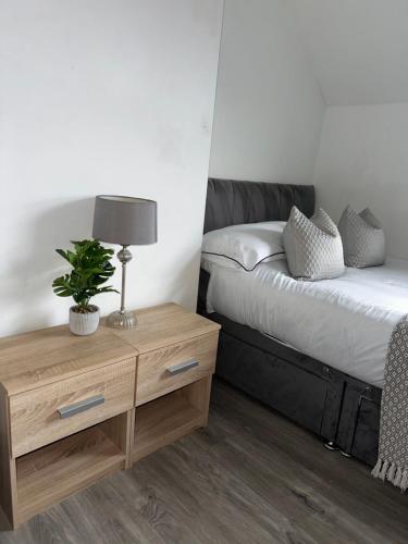 a bedroom with a bed and a table with a lamp at Budget Rooms Lincoln City Centre , Fast WiFi & Self Check in in Lincoln