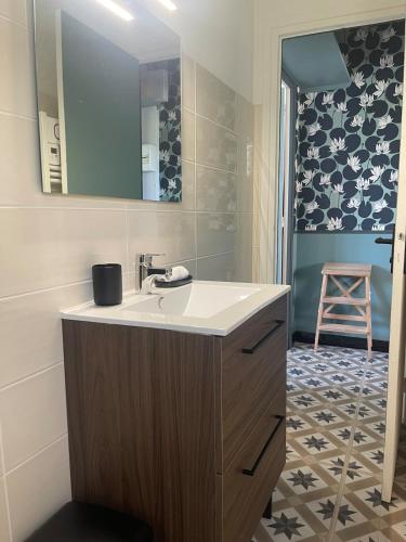 a bathroom with a sink and a mirror at L'instant cocon in Beaumont
