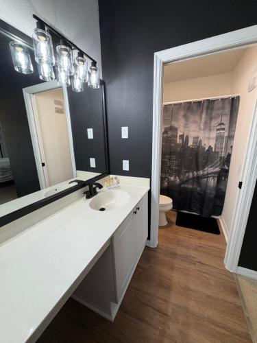 a bathroom with a sink and a mirror at Cozy Disney Stay in Kissimmee