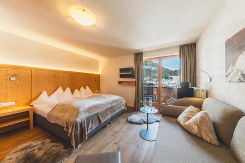 a hotel room with a bed and a couch at Haus Melitta in Lech am Arlberg