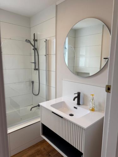 a white bathroom with a sink and a shower at Otaihanga Getaway in Paraparaumu