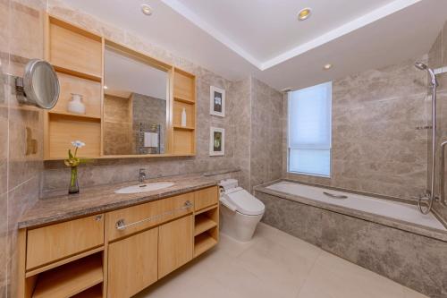 a bathroom with a sink and a toilet and a bath tub at Shangri-La Dalian in Dalian