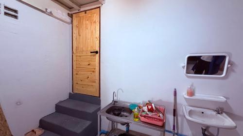 a bathroom with a staircase and a sink and a door at Pink Kraken Hostel in Ban Nong Chaeng