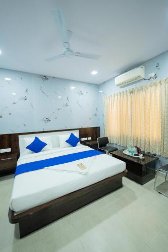 a bedroom with a large bed with blue pillows at Sri Sai Saara Inn in Bangalore