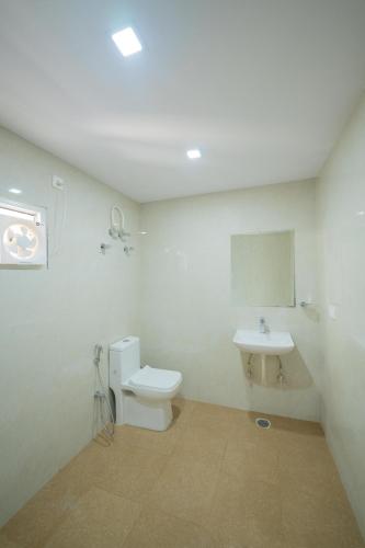 a bathroom with a toilet and a sink at Sri Sai Saara Inn in Bangalore