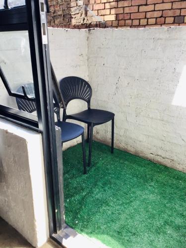 a pair of chairs sitting in a room with green grass at Home at heart in Johannesburg