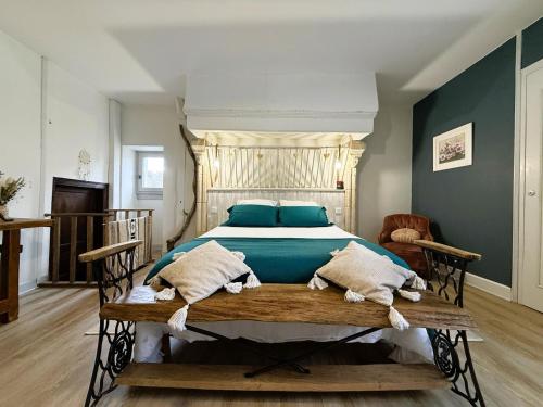 a bedroom with a large bed with blue pillows at Maison luzouÉ in Cardesse