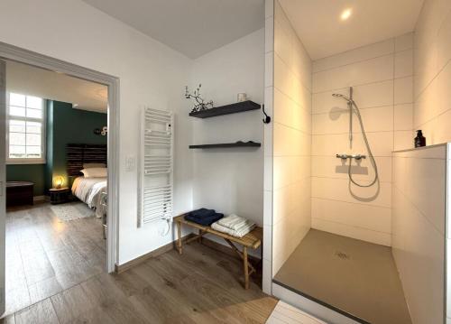 a bathroom with a shower and a bedroom at Maison luzouÉ in Cardesse