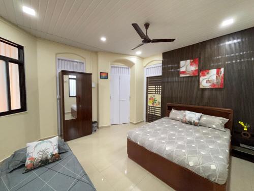 a bedroom with a bed and a ceiling fan at Lilly Beach House in Kīhīm