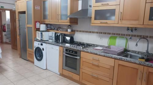a kitchen with a sink and a stove top oven at Casa do Adro in Arcozelo