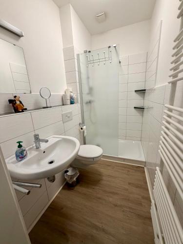 a white bathroom with a sink and a shower at Business Unterkunft Balje 567 - Monteur- & Ferienwohnung mit 7 Einzelbetten in Balje