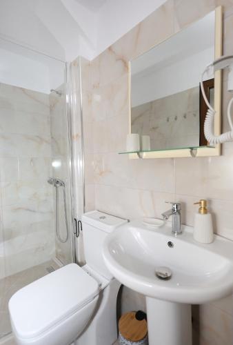 a white bathroom with a sink and a toilet at Guest House Nina in Berat