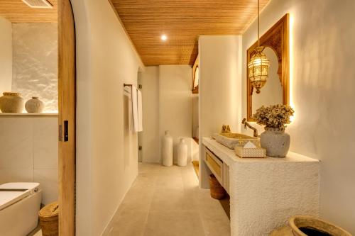 a bathroom with a sink and a mirror at Premaloka in Tanah Lot