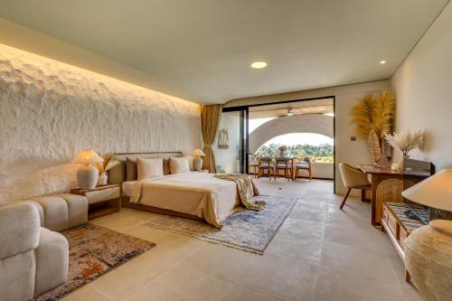 a bedroom with a bed and a living room at Premaloka in Tanah Lot