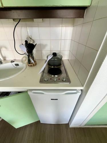 a stove with a pot on top of it in a kitchen at Le Ptit Germain in Saint-Germain-la-Blanche-Herbe