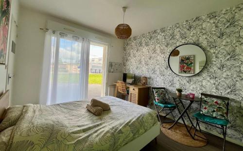 a bedroom with a bed and a mirror and a desk at Le Ptit Germain in Saint-Germain-la-Blanche-Herbe
