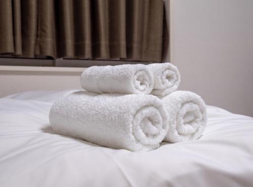 a pile of towels sitting on top of a bed at MEME Villa 5BR - 3 Separate Toilets & 3 Showers - 10Gbps Wifi in Tokyo