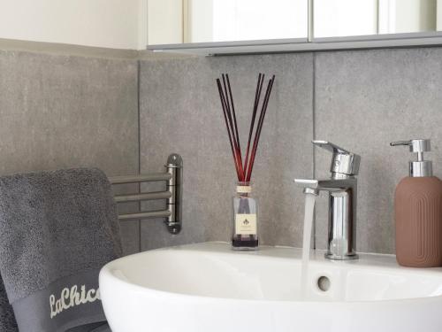 a bathroom sink with a bottle of soap and sticks at La Chicca Appartamento Superior Fucecchio in Fucecchio