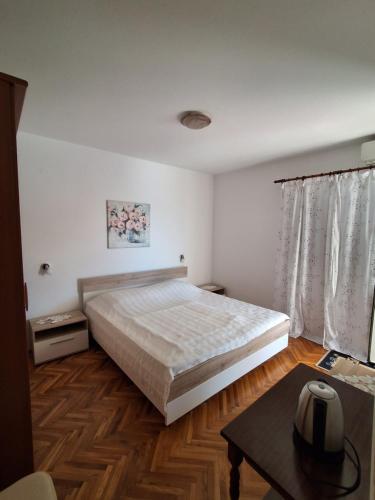 a bedroom with a large bed and a table at Apartments and Studios Vinko Matić in Rab
