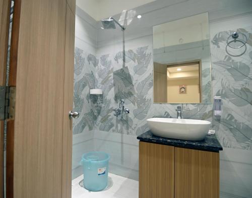 a bathroom with a sink and a mirror at hotel arya inn in Prayagraj