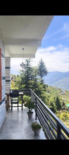 a porch with a table and a bench on a house at Devansh Homestay &Cafe in Kulu