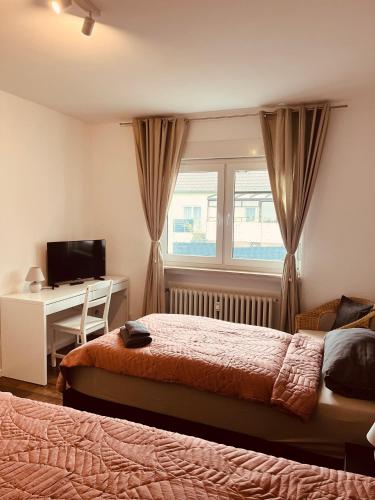 a bedroom with two beds and a desk and a window at Gästehaus Gerschler in Garbsen