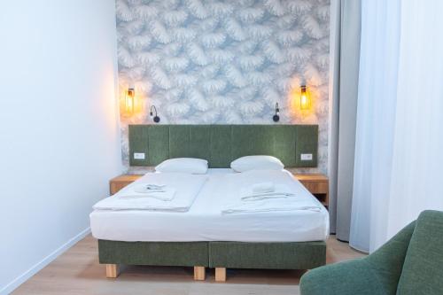 a bedroom with a bed and two chairs at Pilvax Hotel Budapest in Budapest