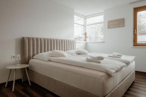 a white bedroom with a bed with towels on it at Riedwohnung 2 in Lustenau