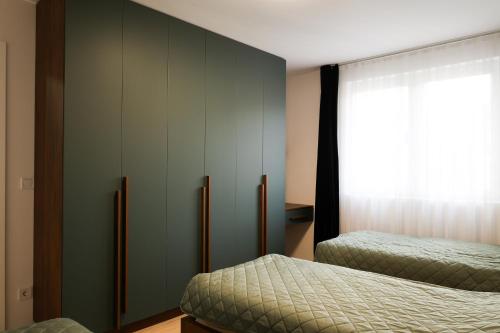 a bedroom with two beds and a large window at Nest apartament in Peje